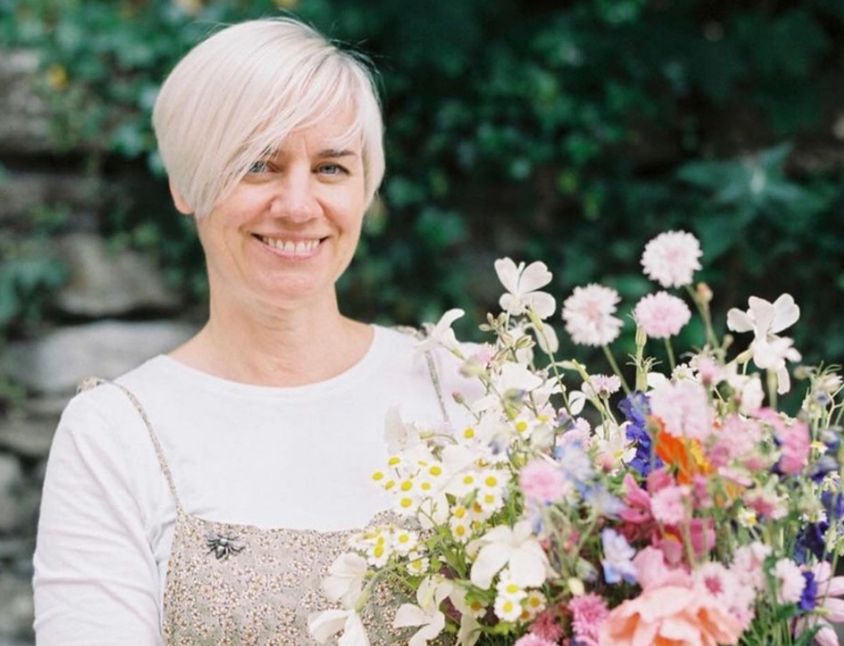 Kirsten of Henthorn Farm Flowers holds a bucket of British cut flowers brimming with scented roses and wildflower style cottage garden varieties.