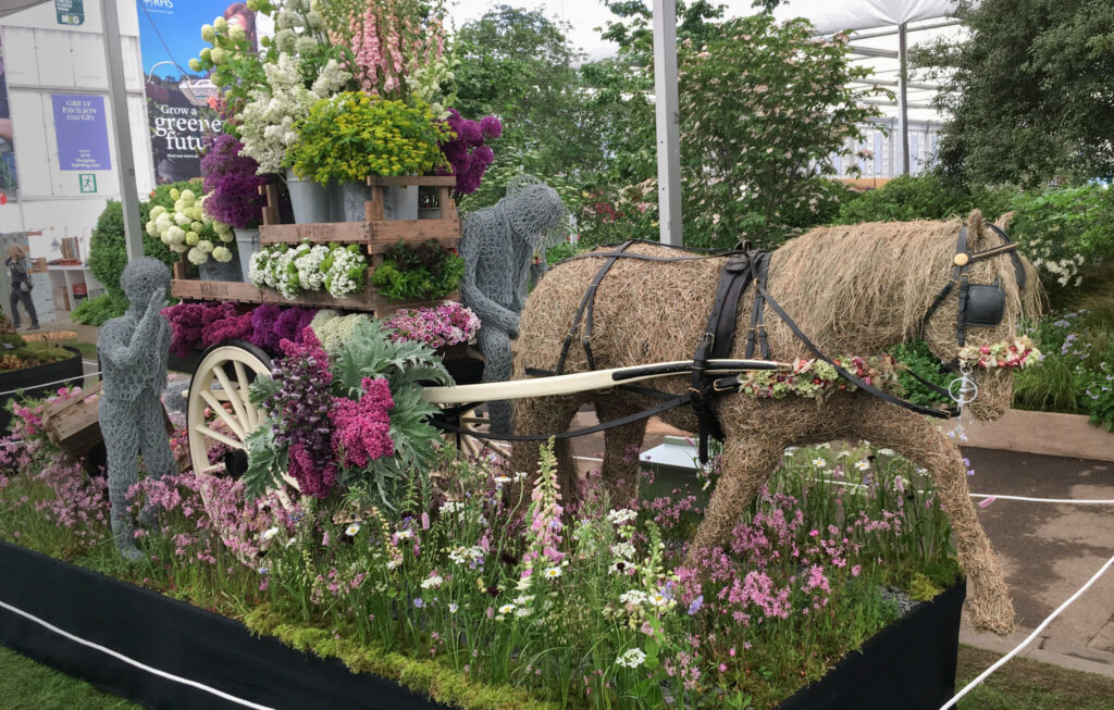 Flowers from the Farm's gold medal winning display at RHS Chelsea Flower Show. Our wire horse, Flora, adorned with dried flowers on her bridal and harness, pulls a cart laden with seasonal British cut flowers along a path of meadow flowers. Photo: Tuckshop Flowers.