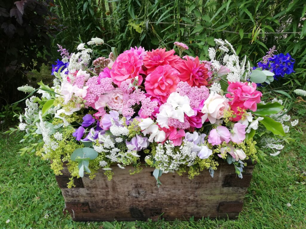 A summer casket spray of seasonal summer flowers by Farhill Flowers