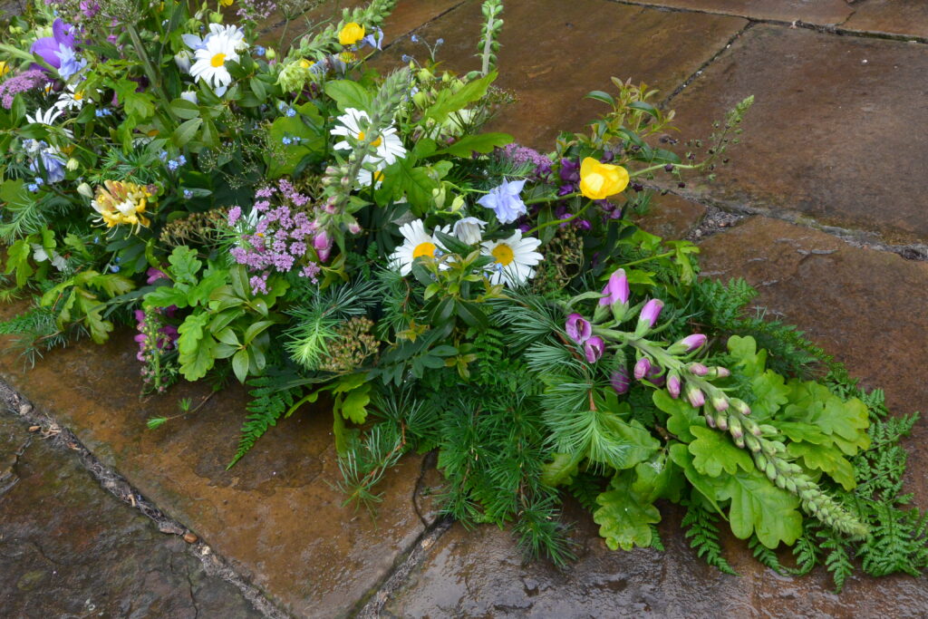 early summer funeral flowers with daisies and foxgloves by Field House Flowers