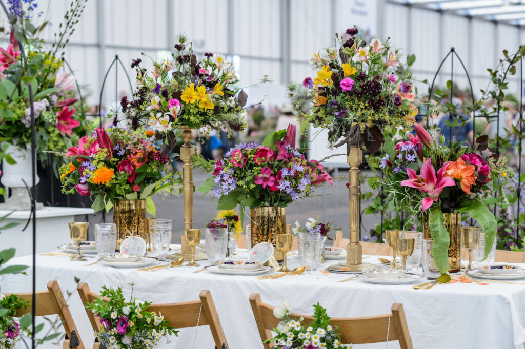 A birthday party table filled with bright flowers at BBC Gardeners World Live. Photo by Jason Ingram.