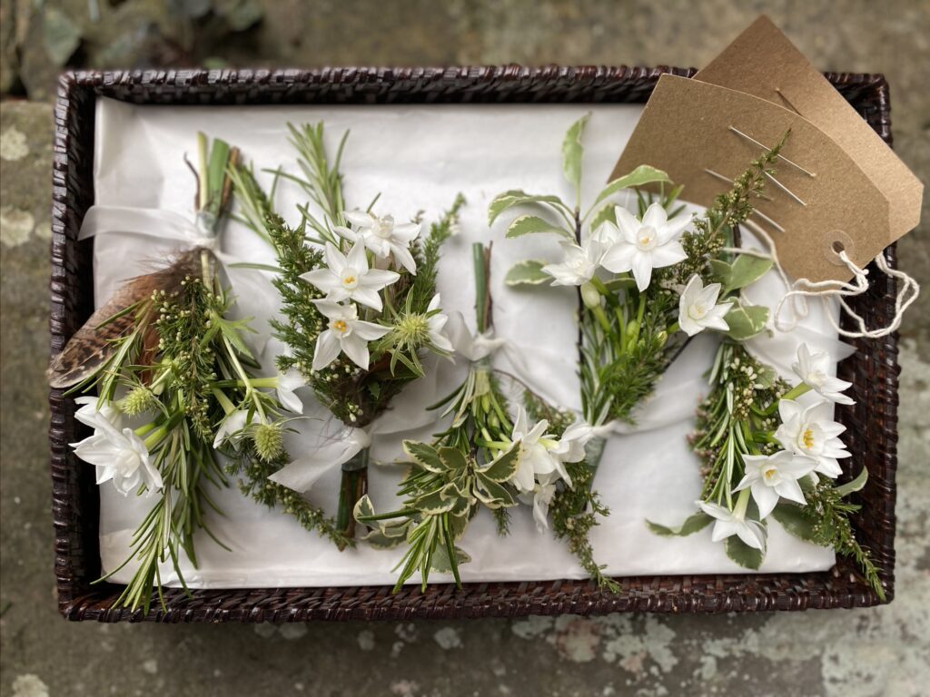 Scented spring buttonholes with white narcissi and rosemary lined up in a vintage tray. By My Flower Patch.Photo Kevin Belson.