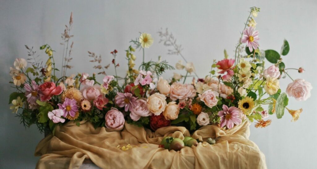 Wildbunch arranges abundant garden roses in a generously scented long low style arrangement for a wedding table