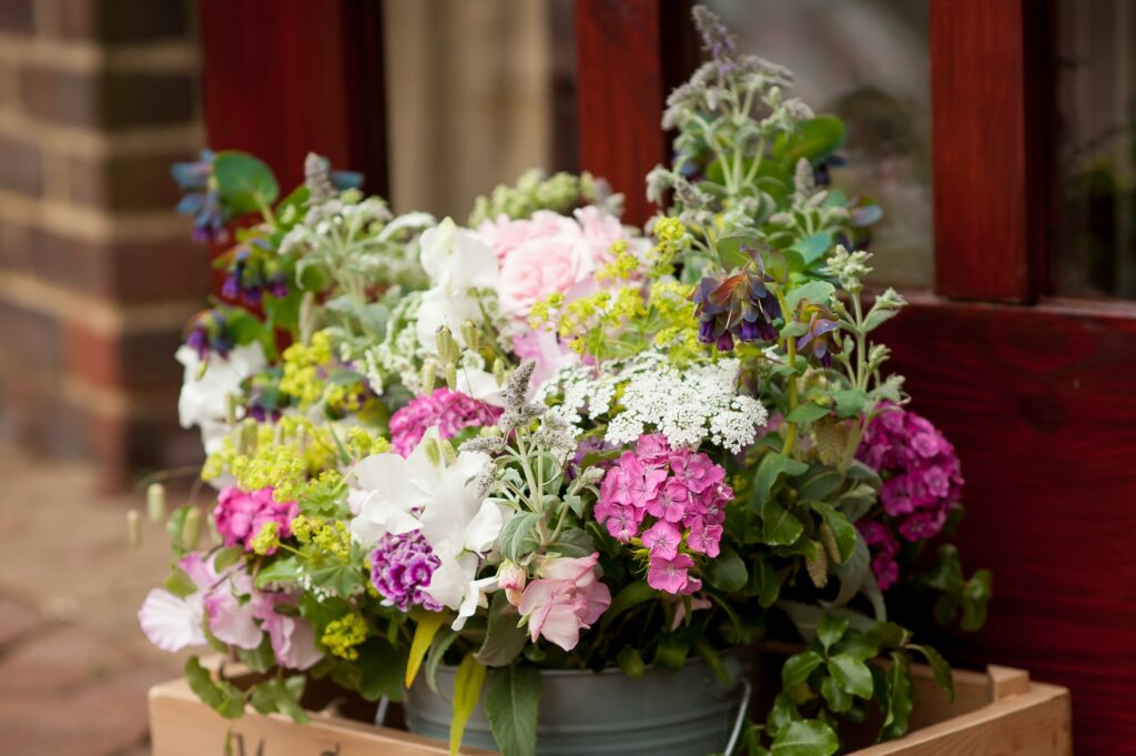 Frothy green lady's mantle brightens this pastel wedding arrangement by Woodchurch Cottage Flowers.