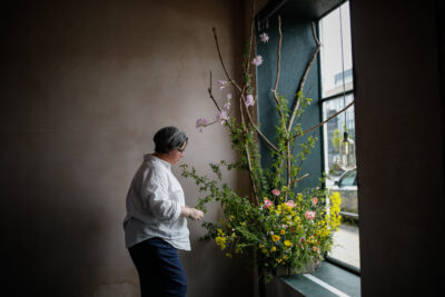 Rachel of Hedgerow adds the finishing touches to her wild window display for British Flowers Week in Edinburgn. Photo: Solen Photography