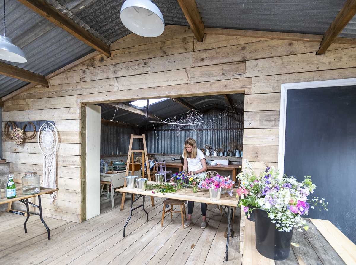 Lucy of Wye Valley Flowers arranging flowers in her workshop