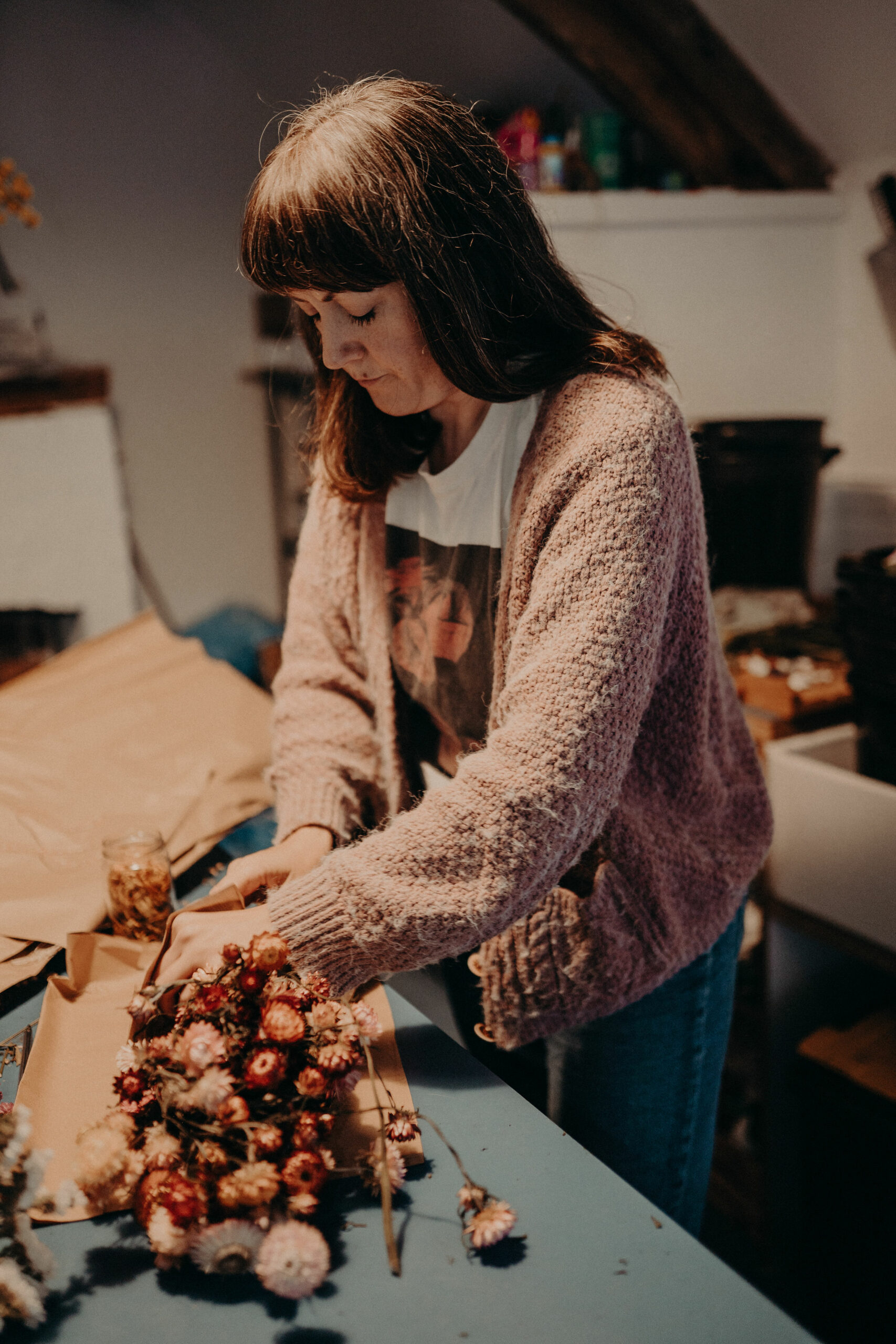 Lucy Marshall of Deadhead Flower Farm wrapping bunches of dried flowers grown and dried at her farm