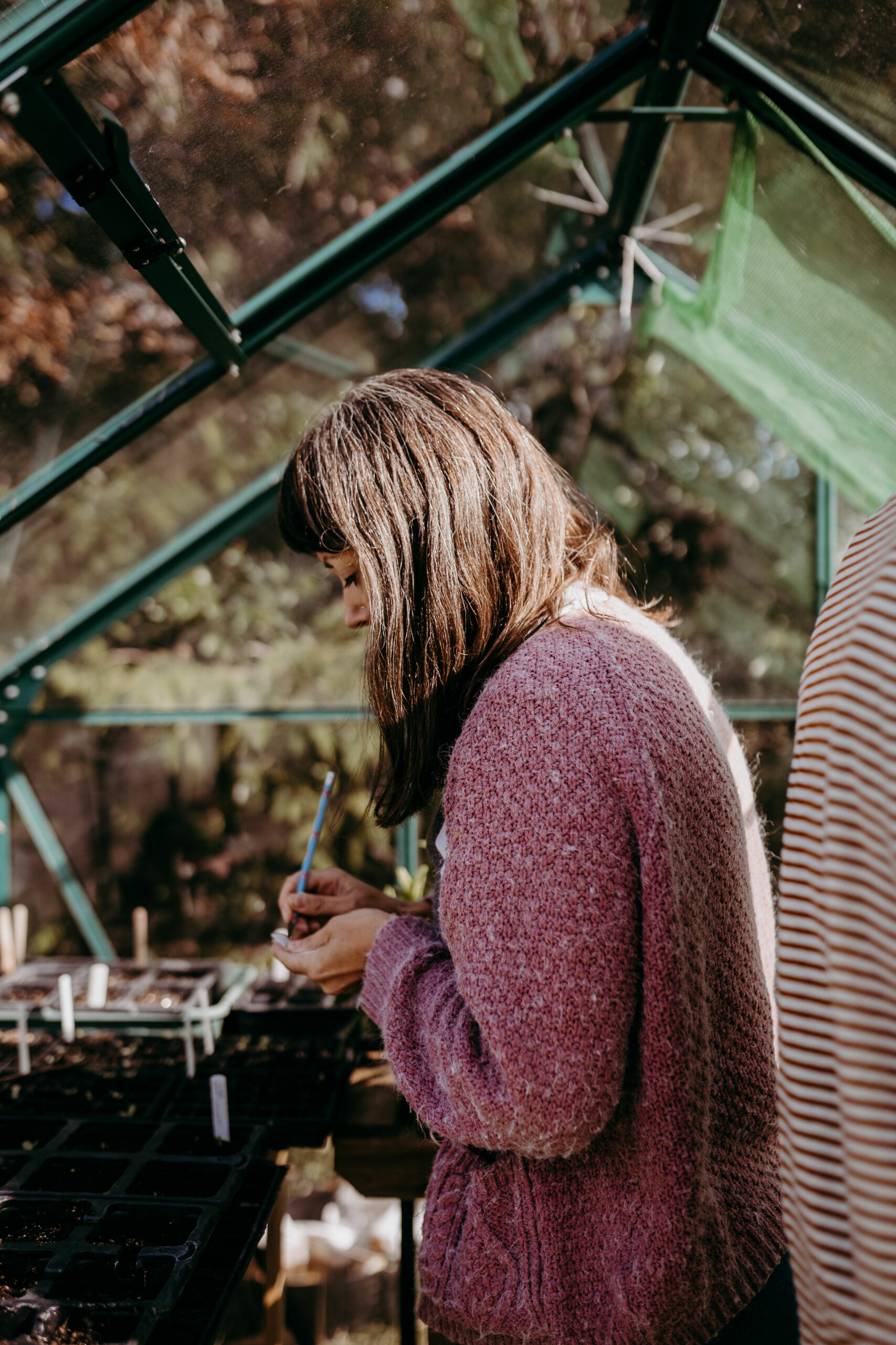 Lucy Marshall of Deadhead Flower Farm sowing seeds in her greenhouse