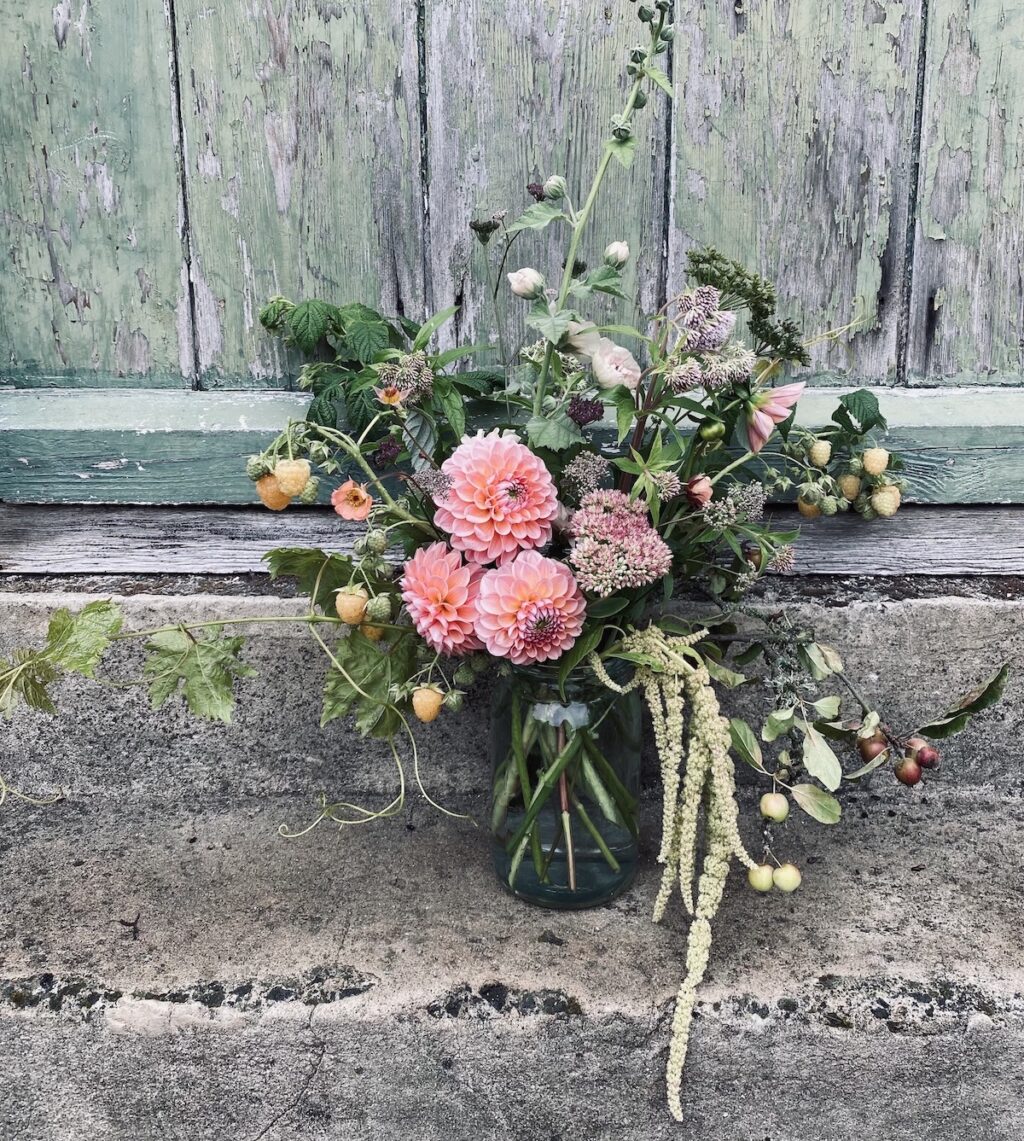 A jar of autumn flowers and fruits