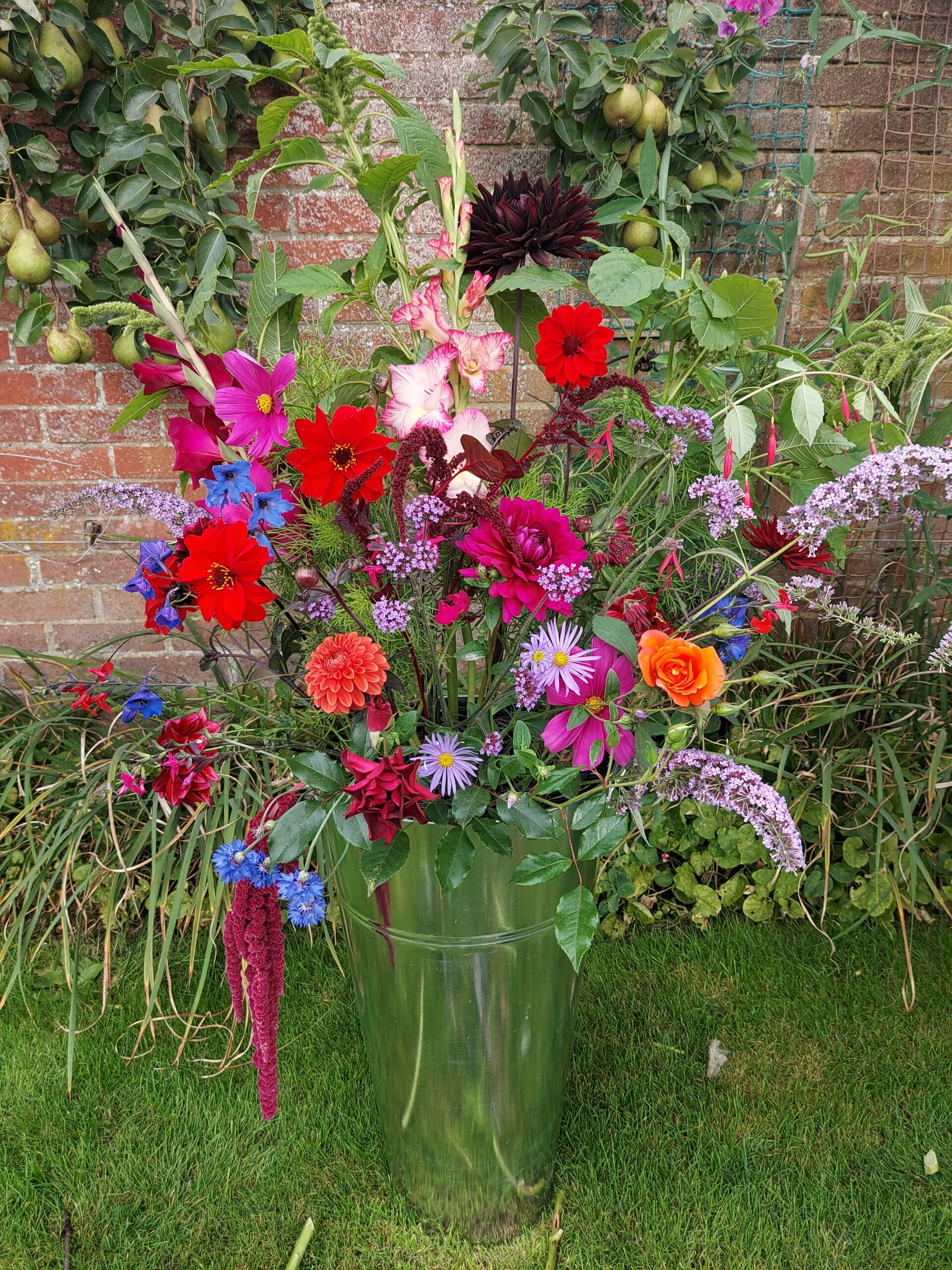 A bright and beautiful bucket of late summer British blooms, arranged using foam-free mechanics