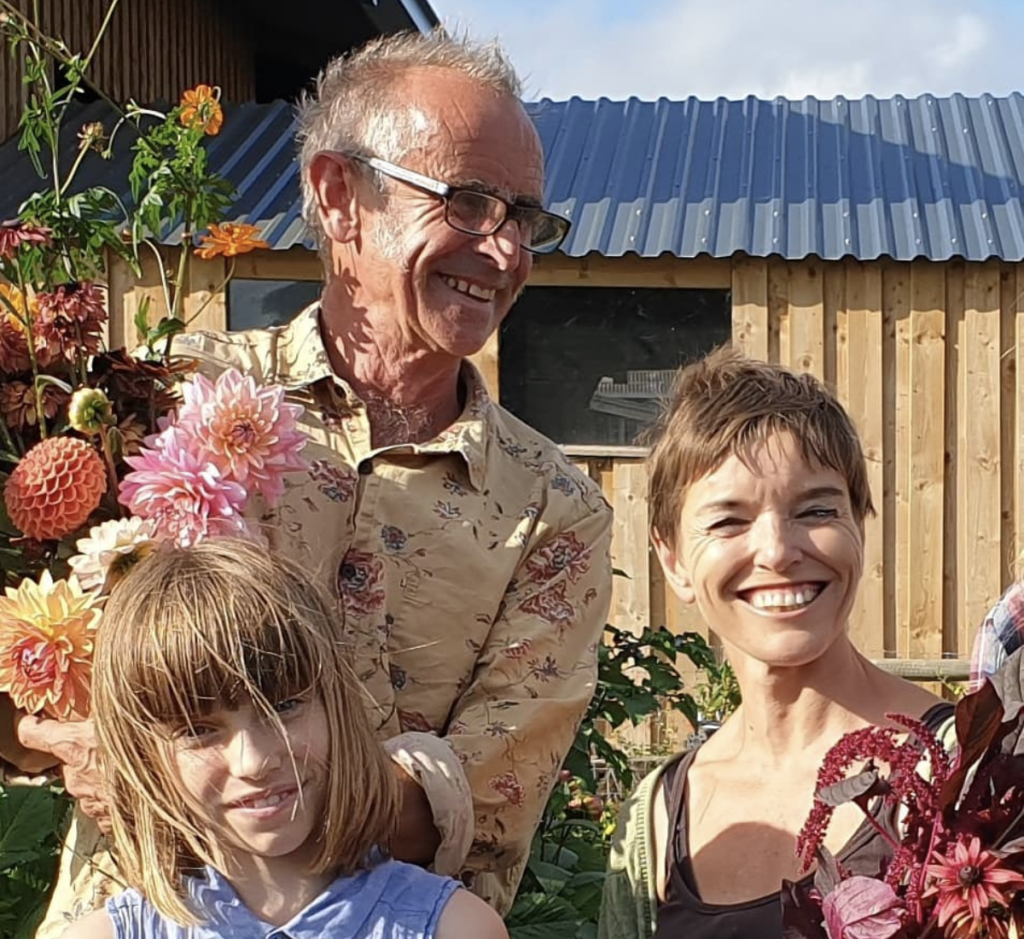 Paul & Helen Stickland with daughter Tabitha pictures with armfuls of flowers at their farm