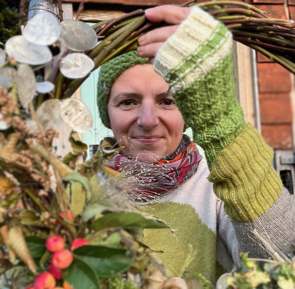 Suzy Cubit-O'Neil holding one of her Christmas wreaths made from foliage, berries, dried flowers and seed heads all grown on and around her cutting garden in Northamptonshire