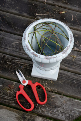 a tangle of stems in a ceramic urn supports a large scale arrangement.