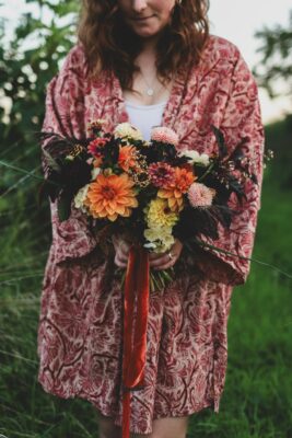 Laurenne Hopkins holding a stunning bouquet made up of autumanal colours